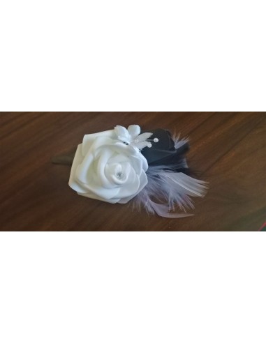 Boutonnière mariage faite avec des roses et plumes noir et blanc