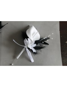 Boutonnière de mariage faite avec un arum blanc et des plumes noires